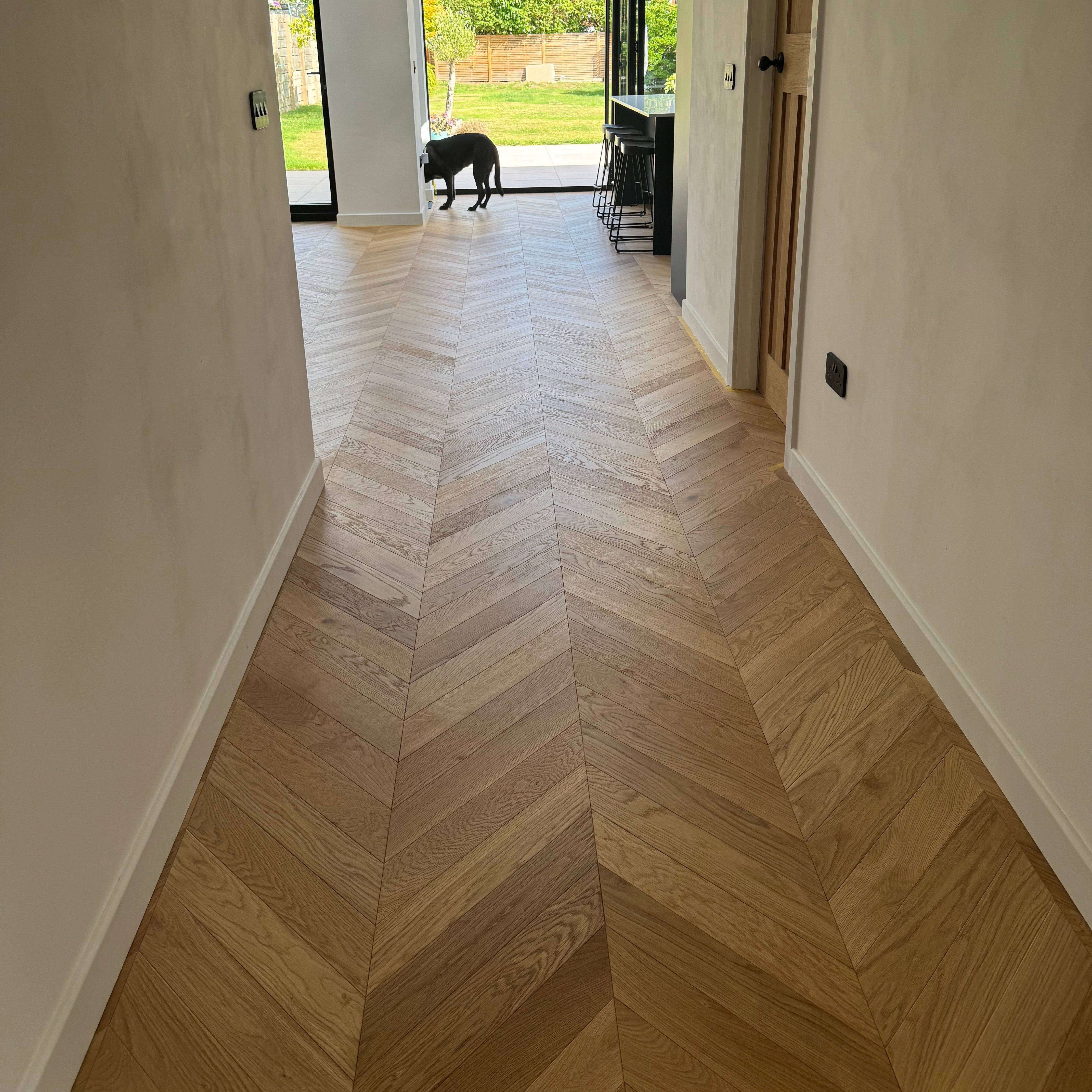 Modern interior with wooden floor and glass door leading to garden